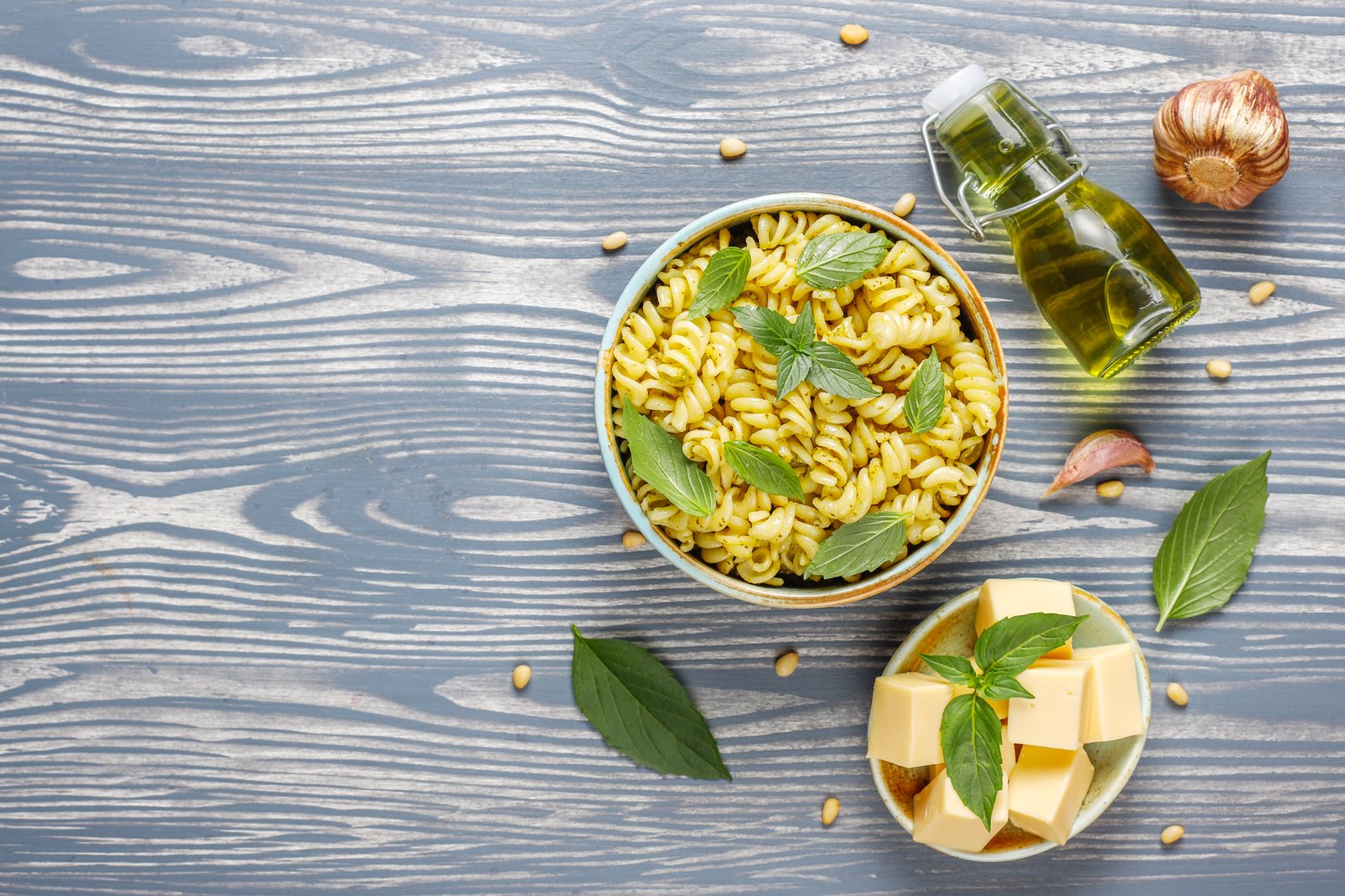 Butter und Olivenöl neben einer Schüssel Nudeln