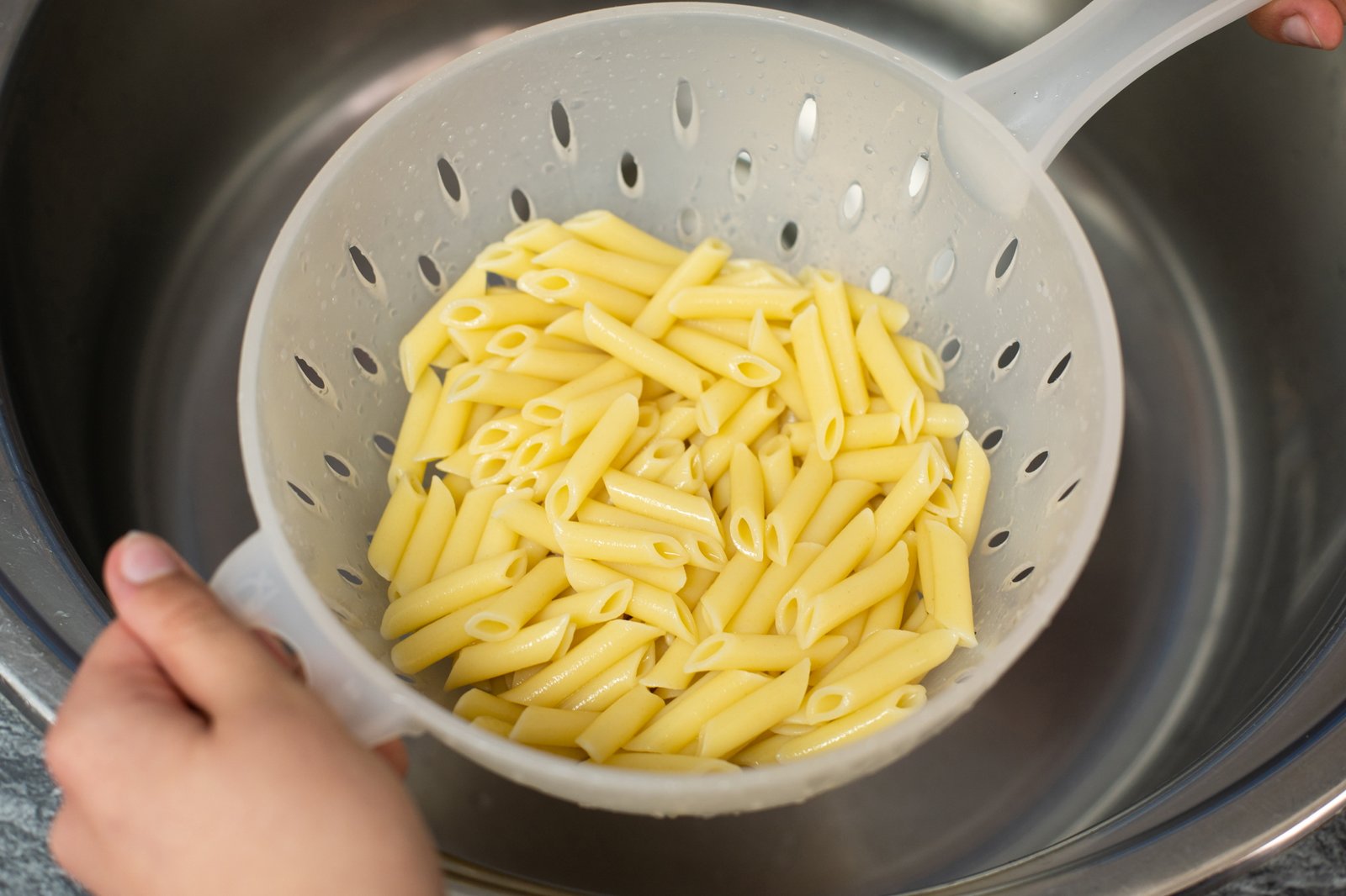 Abgetropfte Nudeln in einem Sieb in der Küche