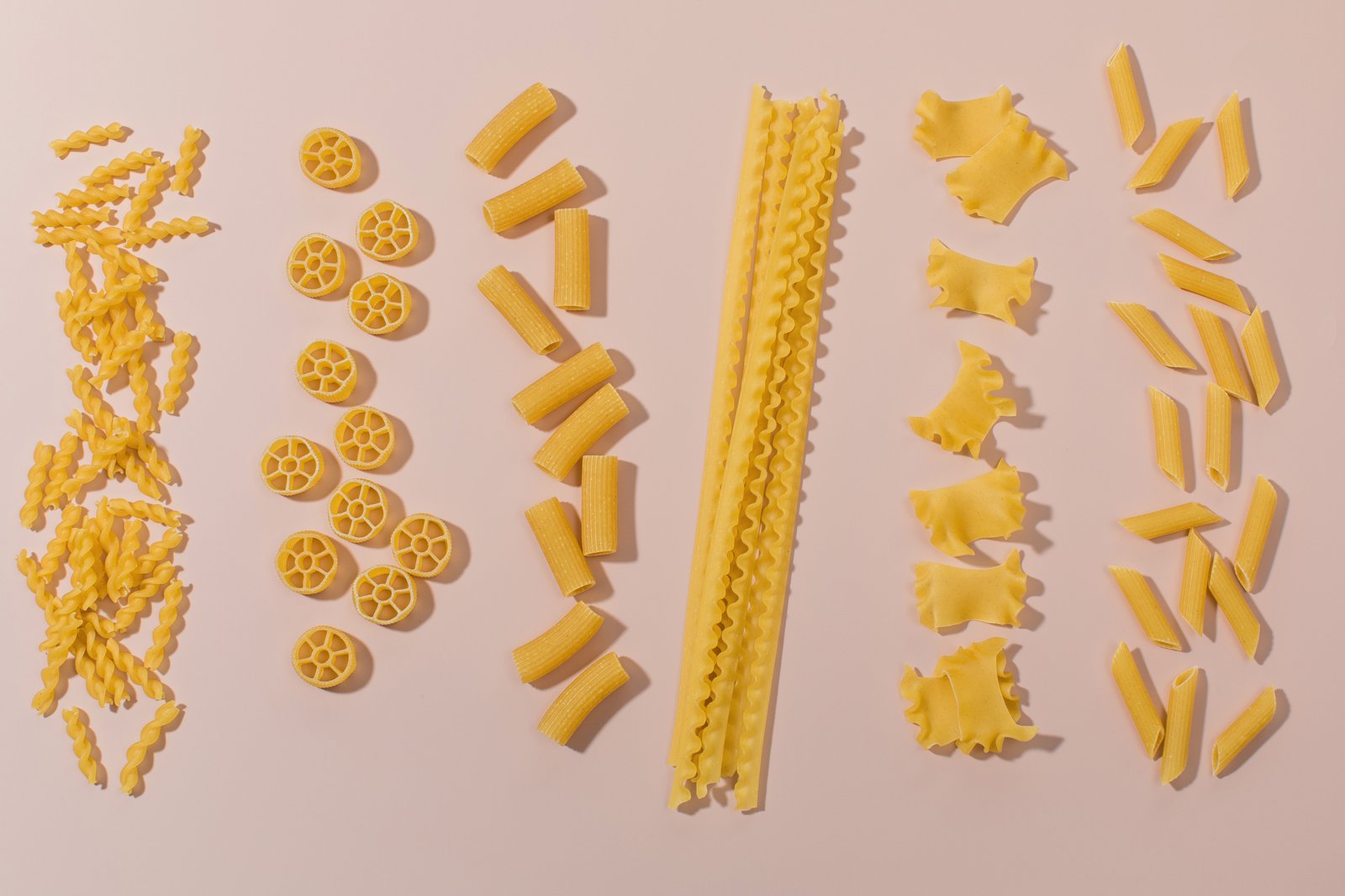 Penne und Spaghetti nebeneinander auf einem Holzbrett